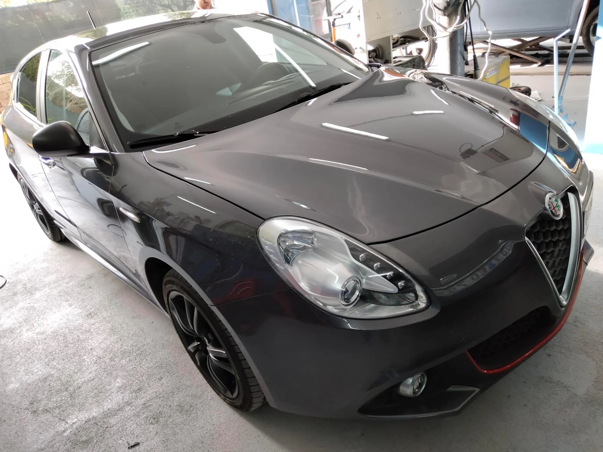 Alfa Romeo Giulietta riverniciata grigio antracite, vista frontale tre quarti in garage