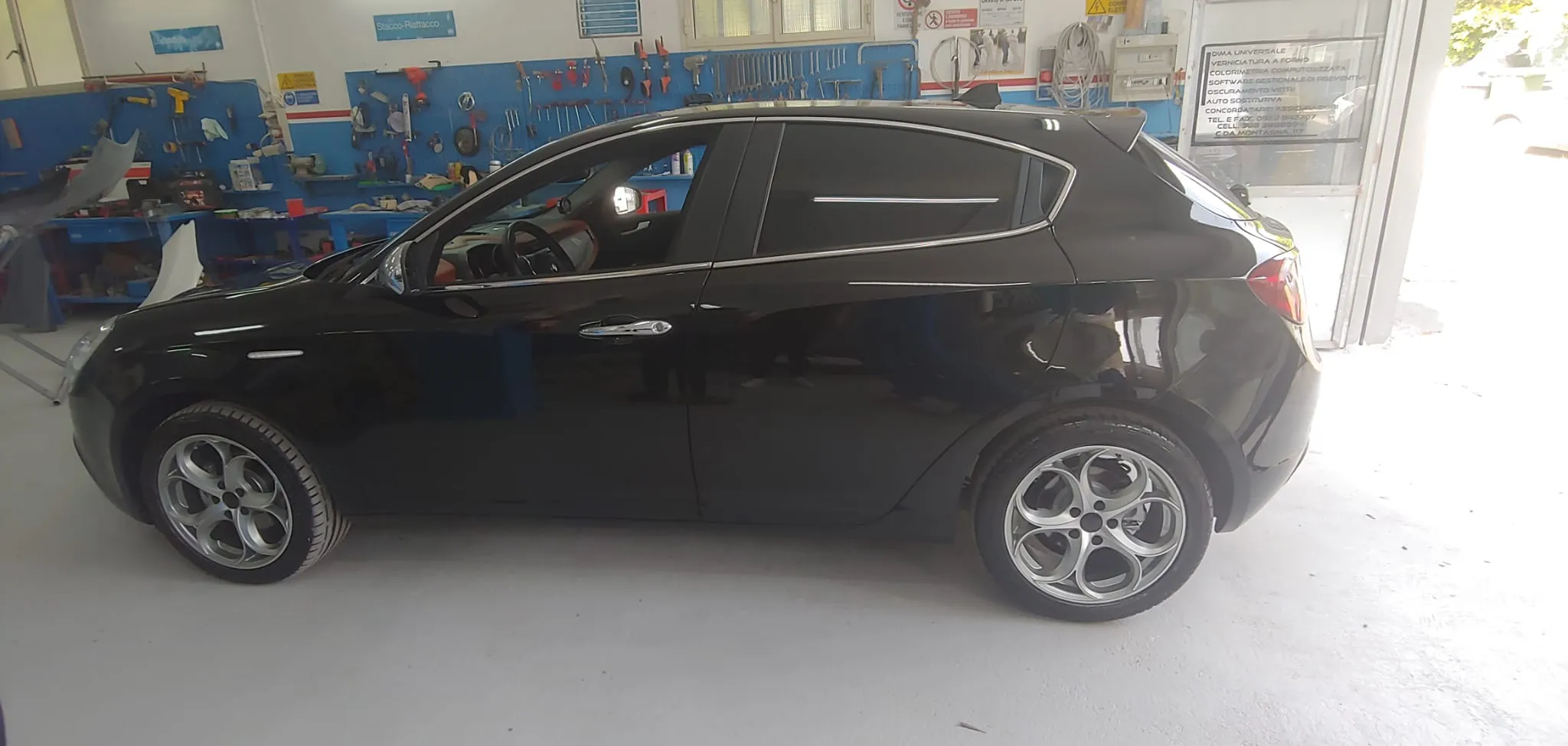 Alfa Romeo Giulietta nero brillantinato, profilo laterale in officina