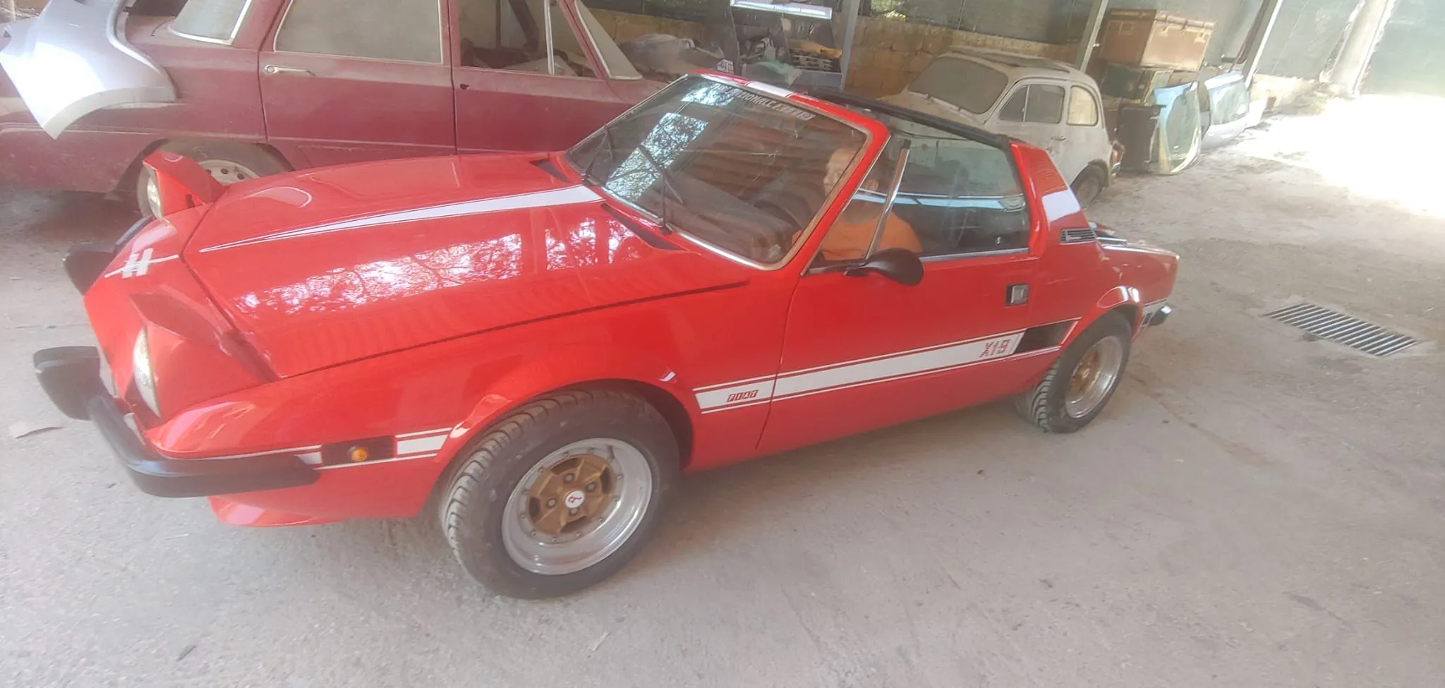 Fiat X1/9 d'epoca restaurata, parcheggiata tra auto storiche