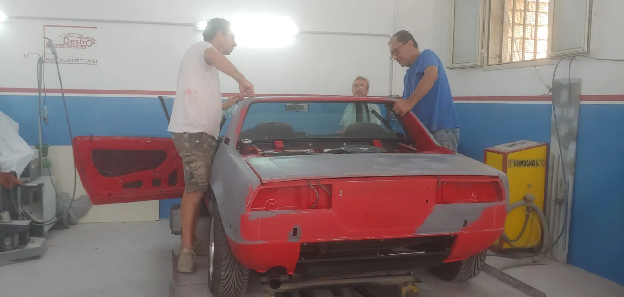Fiat X1/9 in fase di restauro, scocca rossa parzialmente verniciata