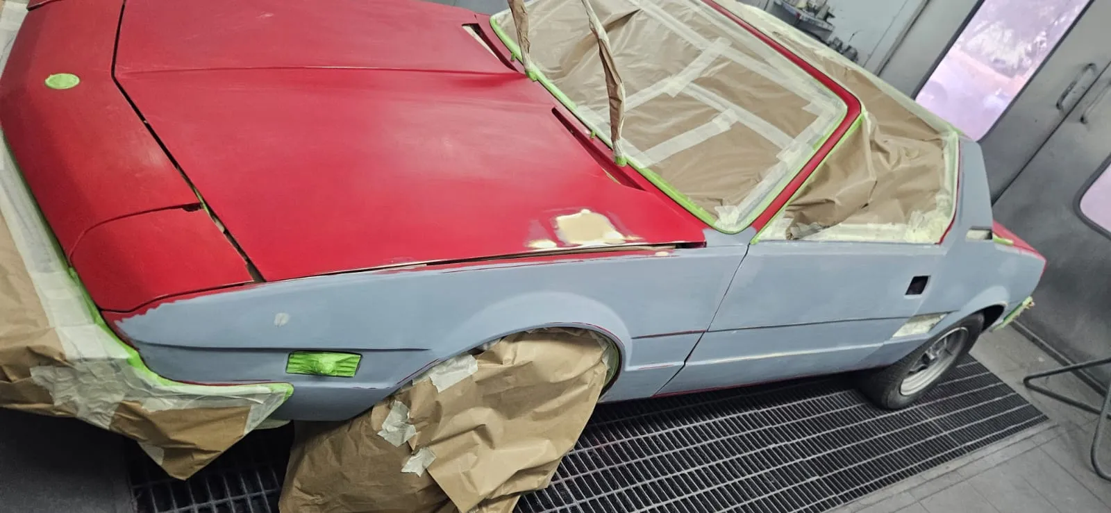Fiat X1/9 in cabina di verniciatura durante il restauro, transizione al colore rosso
