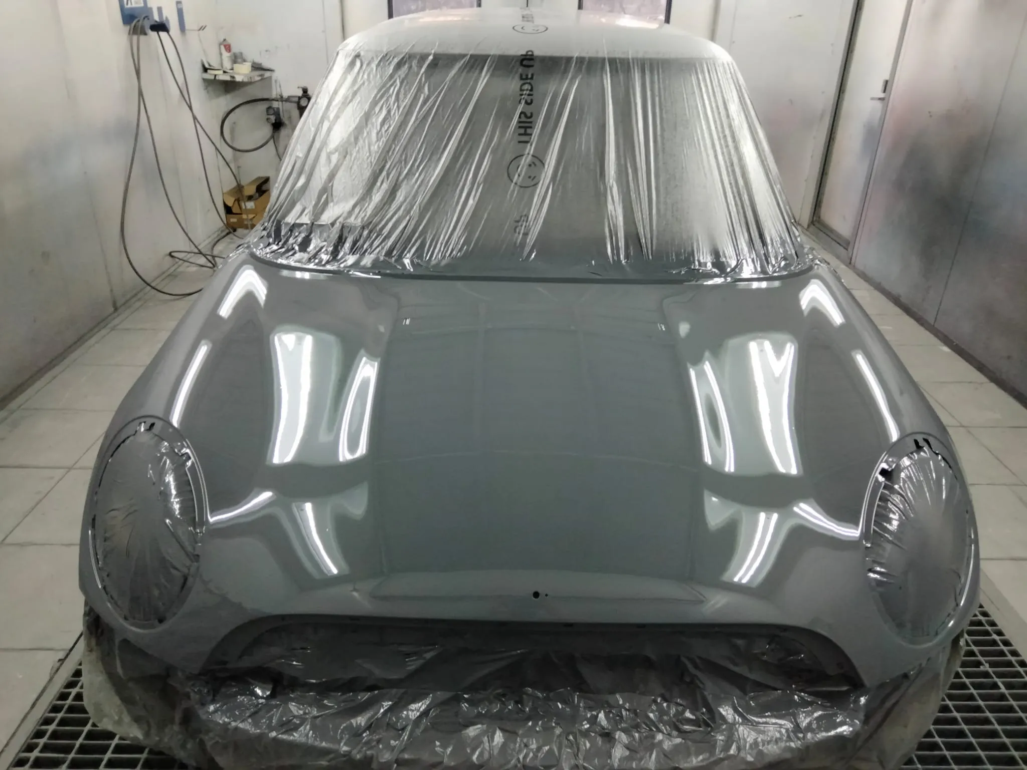 Mini Cooper in cabina di verniciatura, fiancata grigia mascherata