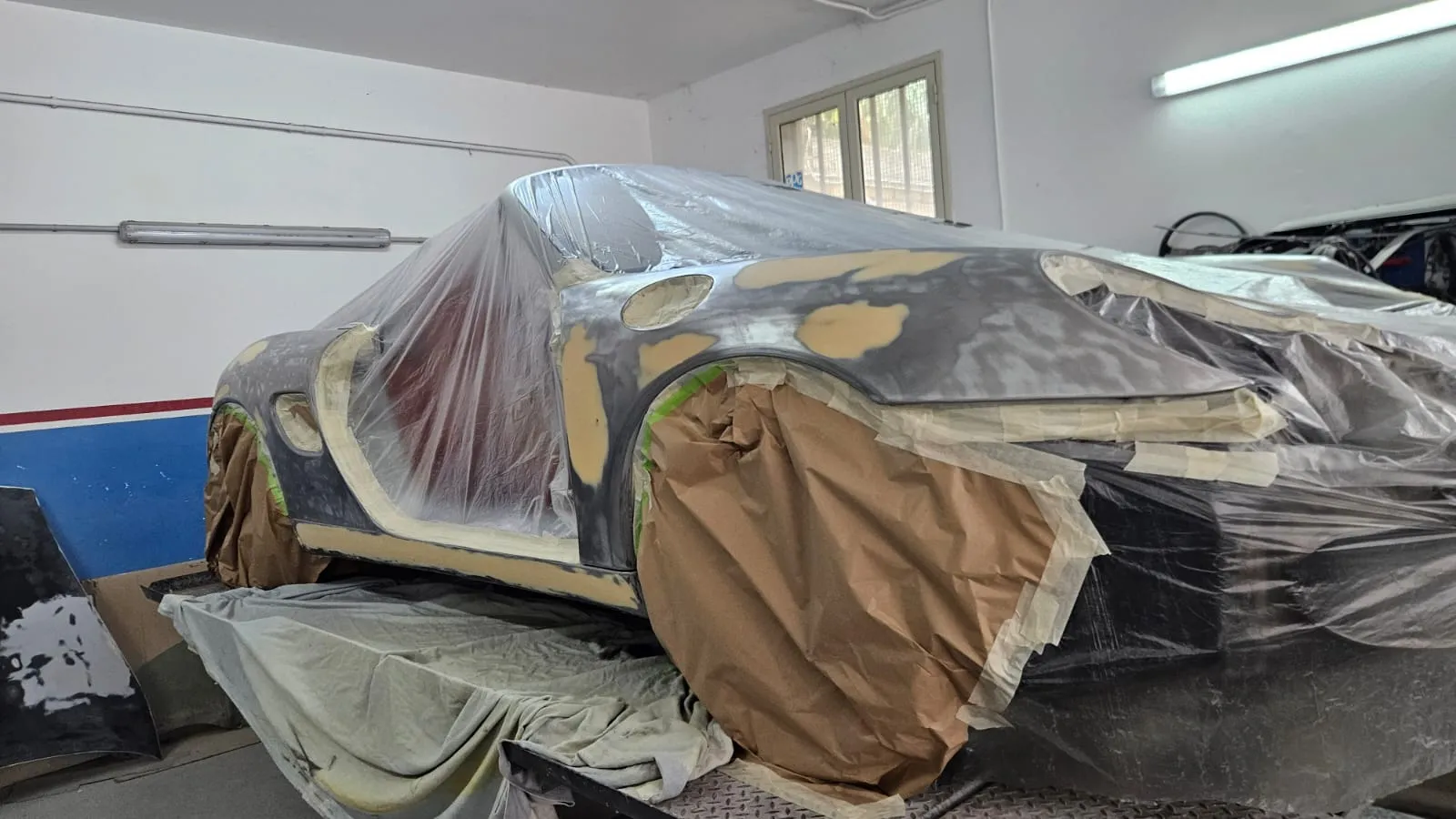 Porsche Boxster in primer grigio, fiancata con giunture mascherate